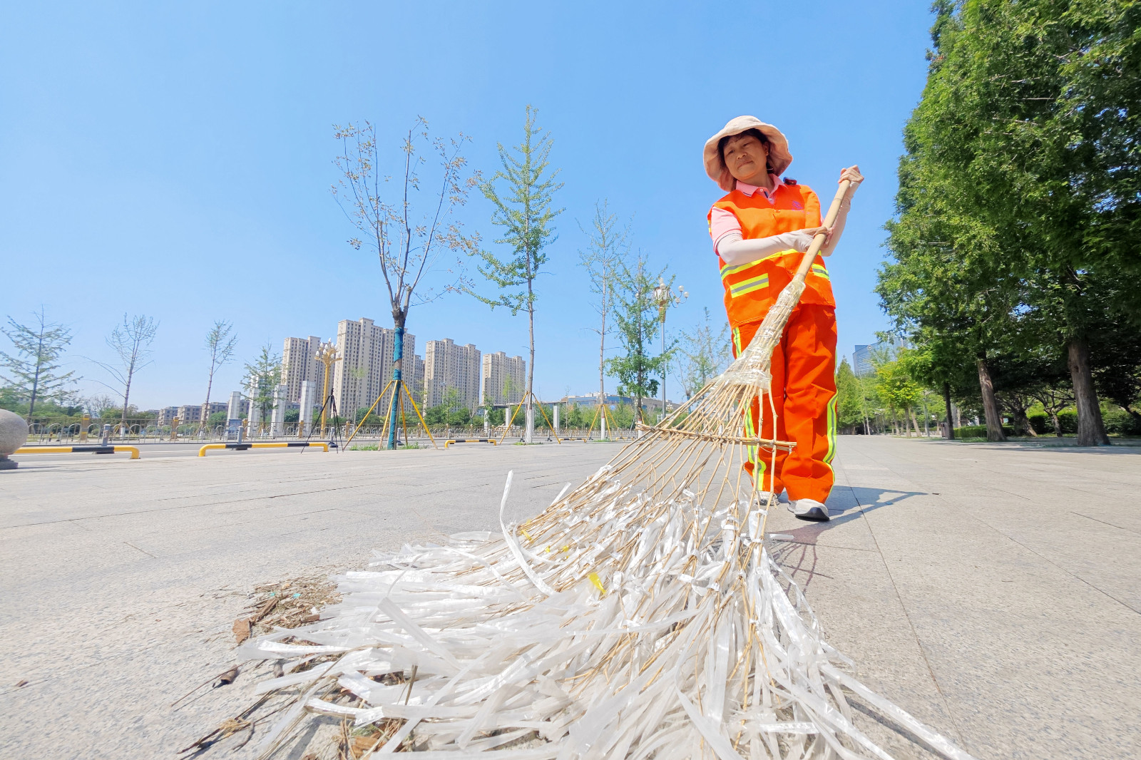 烈日下，環(huán)衛(wèi)工人正在清理路面