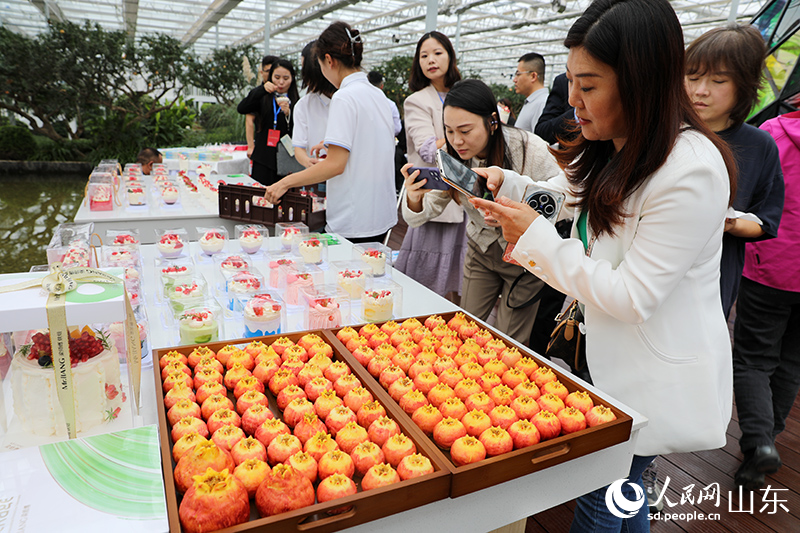 与会嘉宾品尝、拍摄石榴相关产品。人民网记者 刘祺摄