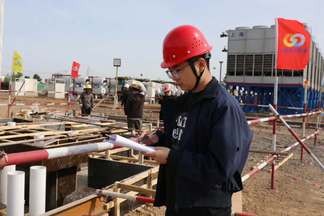王嘉良在施工现场记录工程进度.JPG