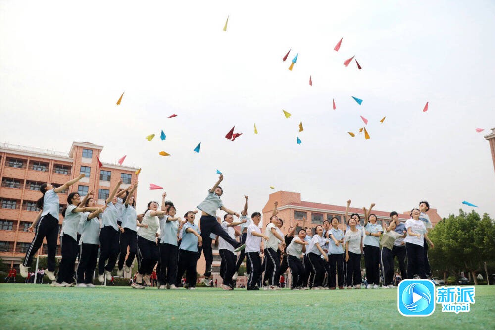高三学生将写有各自梦想的纸飞机抛向空中。