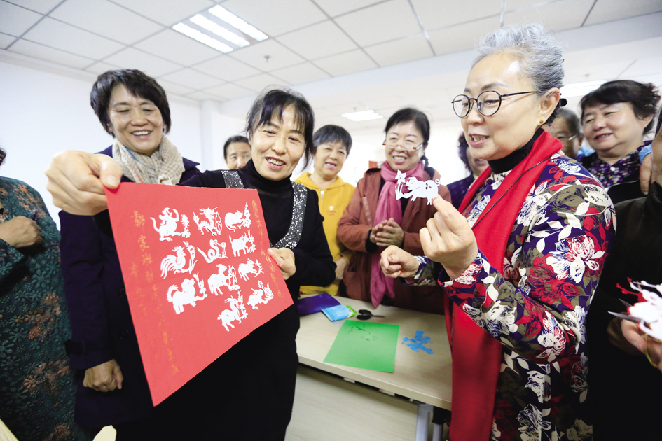 包头市老年大学剪纸教师张丽与学员交流