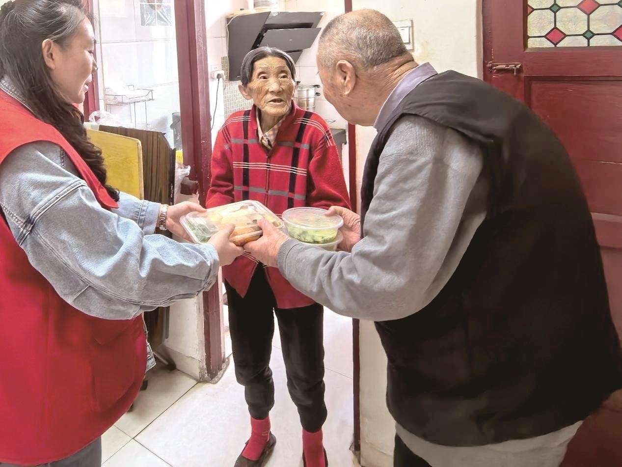 工作人员将热乎的饭菜送到居民家中。