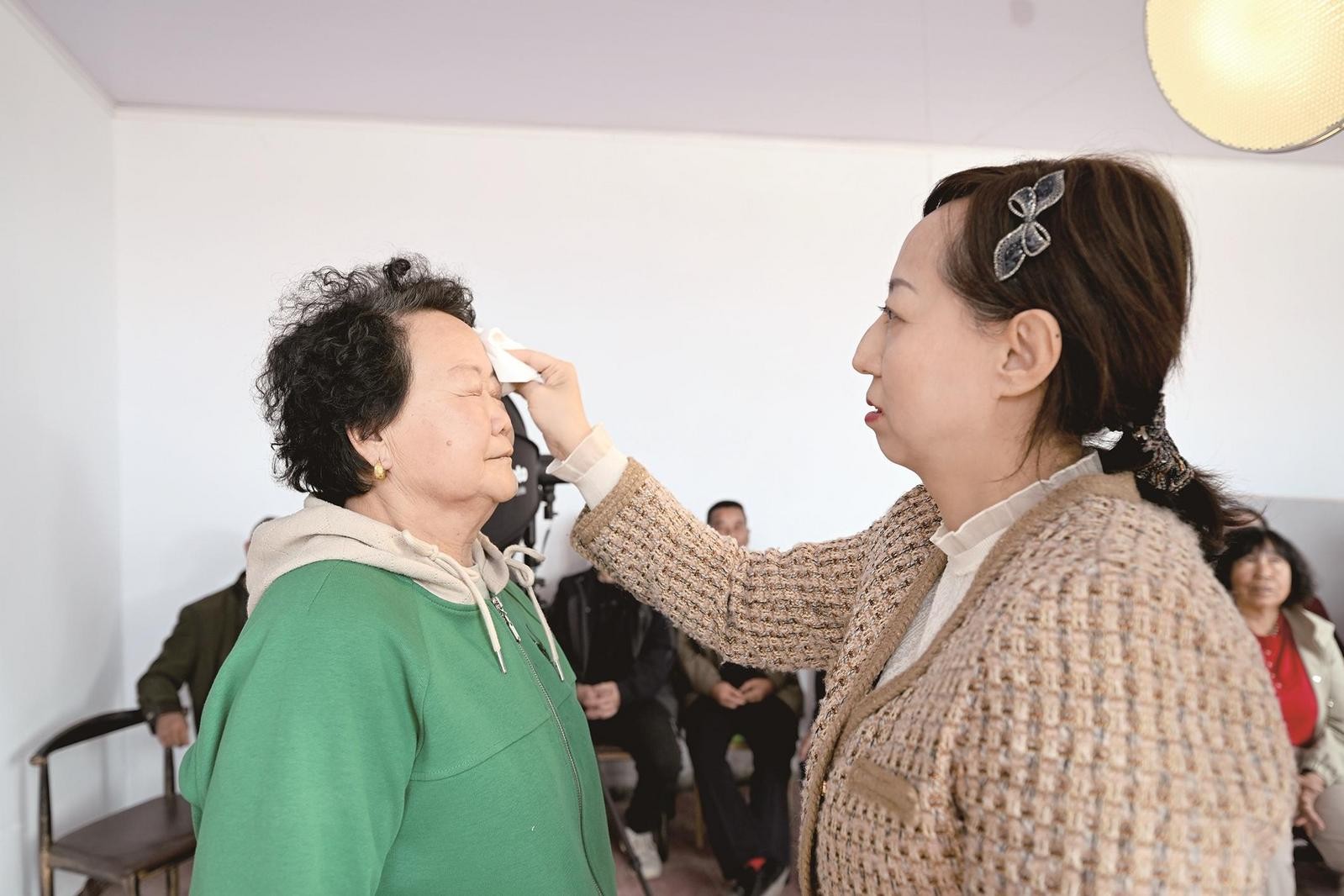 任俊的爱人为村民拭去头上的汗。