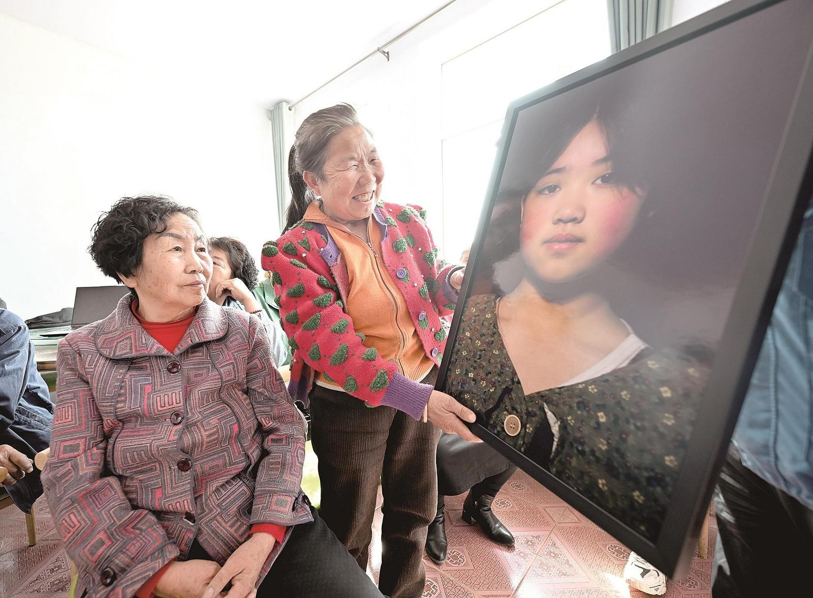 村民看到村里孩子的照片时,欣喜不已。