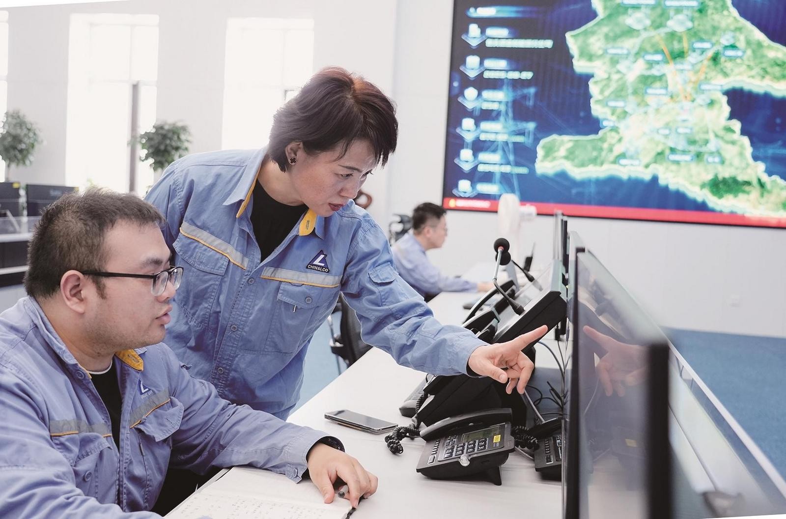包头铝业调度通信中心经理徐俊霞与同事沟通相关数据内容。