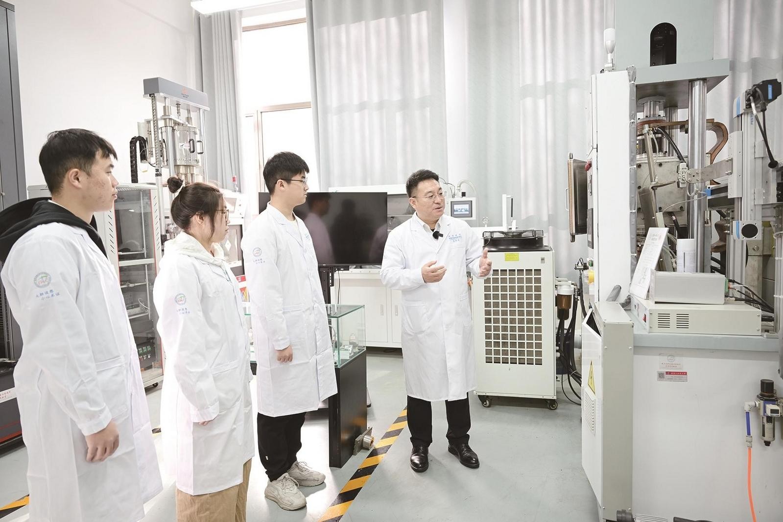内蒙古科技大学稀土材料电磁冶金技术与应用实验室内，张新房教授正在指导学生。
